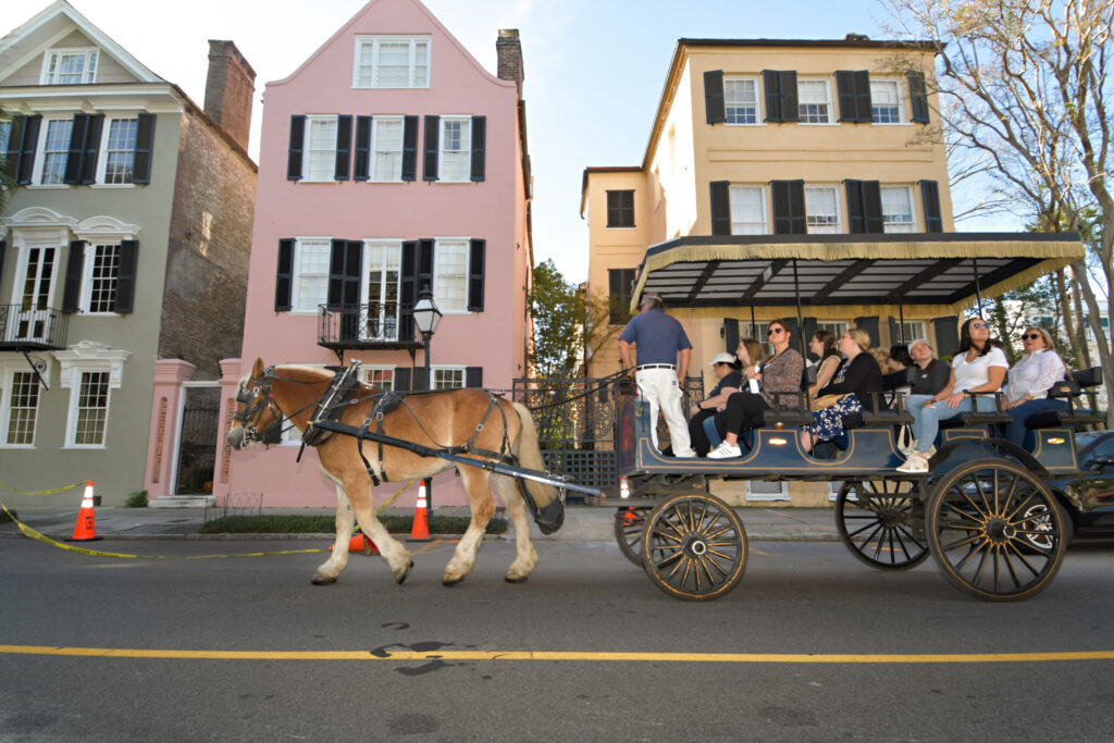a man riding a horse drawn carriage in front of a building